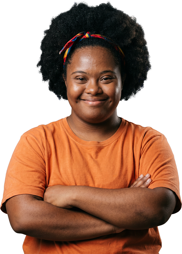 Jovem com síndrome de Down de camiseta laranja, braços cruzados, sorrindo para a câmera.